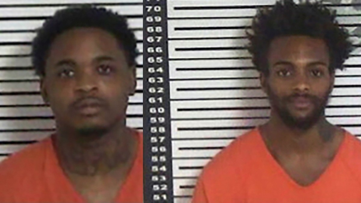 Dos hombres de piel morena con traje de reo en color naranja