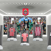 Una exhibición de la historia de Chivas en un museo, mostrando cinco camisetas históricas del club en vitrinas transparentes, con una foto del equipo campeón de