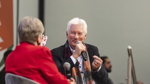 Richard Gere en la FIL Guadalajara. con un microfono antes de los abucheos