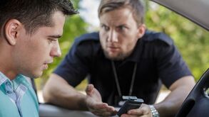 Imagen de un conductor con un agente de vialidad que realiza el operativo alcoholímetro.