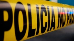 Se observa una cintilla amarilla de precaución, que dice policía con letras negras.