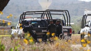 Policías abajo de una patrulla en un campo abierto.