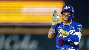 Un jugador de béisbol de los Charros de Jalisco (uniforme azul) sonríe y levanta el guante con la mano abierta, celebrando en el campo durante un partido