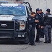 Oficiales parados junto a una patrulla de la Policía Municipal de Guadalajara estacionada en calles donde se hallaron a tres personas