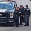 Oficiales parados junto a una patrulla de la Policía Municipal de Guadalajara estacionada en calles donde se hallaron a tres personas