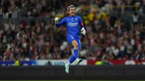 La portera de Chivas, Blanca Félix (uniforme azul y cabello teñido de blanco), salta y sonríe con los puños cerrados celebrando una victoria.