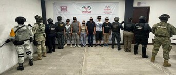 Hombres y mujeres de pie y con los ojos censurados en instalaciones de la Fiscalía de Chiapas con militares parados de espaldas a los costados