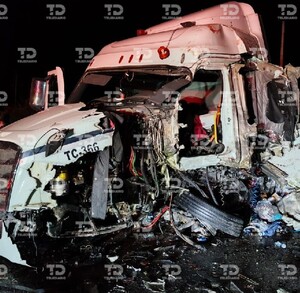 Se observa un tráiler blanco destrozado y unos hombres a un costado.