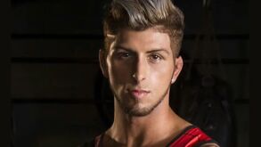 Thiago Arroyo, famoso participante de reality deportivo, en una sesión de fotos con un fondo negro.