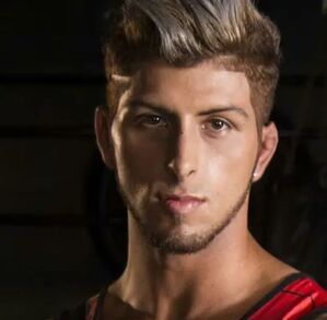 Thiago Arroyo, famoso participante de reality deportivo, en una sesión de fotos con un fondo negro.