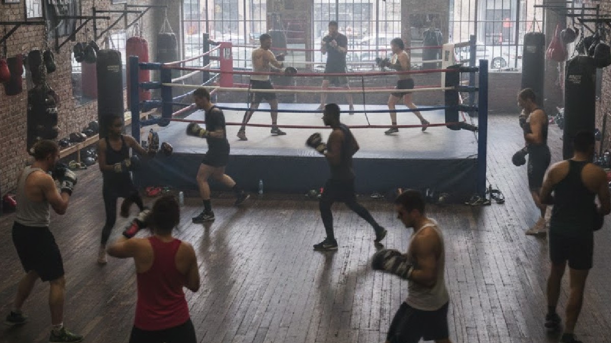 Varios hombres con guantes de boxeo arriba del ring