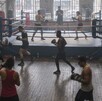 Varios hombres con guantes de boxeo arriba del ring