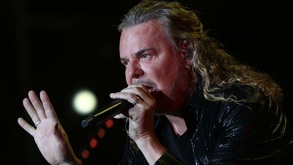 Fernando Olvera, vocalista de Maná, con un micrófono sobre las manos.