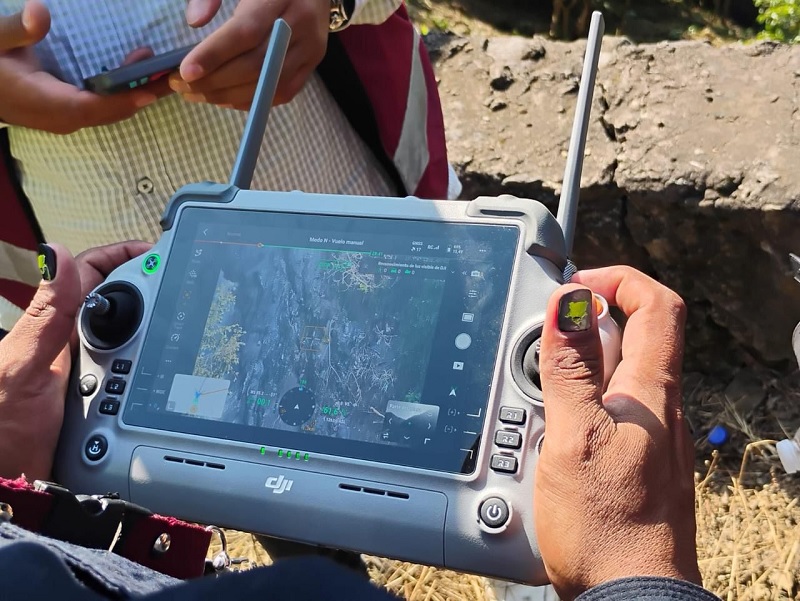 Una persona manejando un dron a la distancia.
