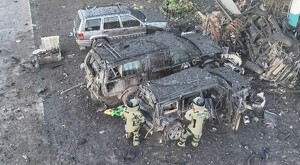 Vista aérea de automóviles calcinados y escombros tras la explosión en Michoacán con militares del ejército mexicano revisando uno de los vehículos