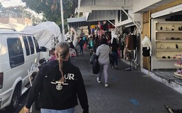 Grupo de personas caminando en calle, locales a la derecha