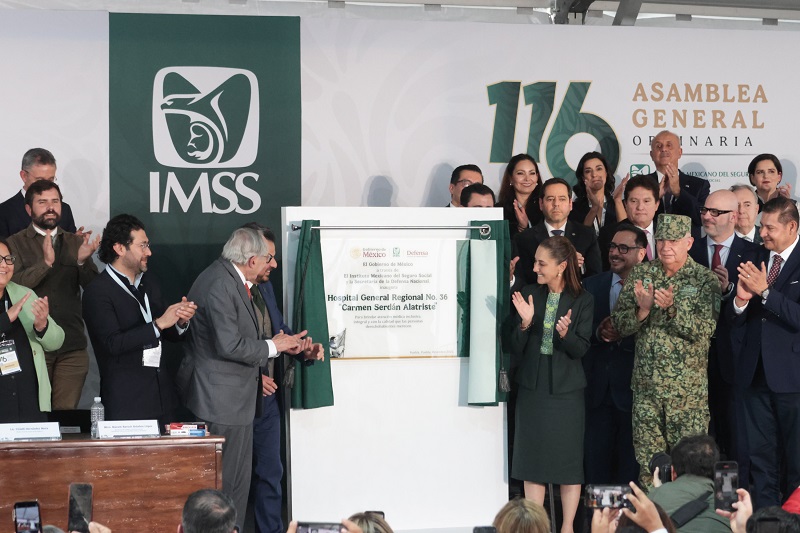 Personas revelando una placa con el nombre de un hospital en Puebla.