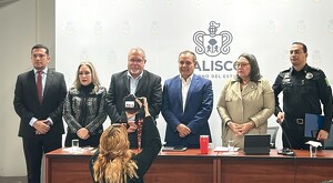 Funcionarios de seguridad en Jalisco siendo fotografiados de pie delante de una mesa ante los medios de comunicación en conferencia de prensa