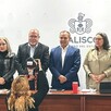 Funcionarios de seguridad en Jalisco siendo fotografiados de pie delante de una mesa ante los medios de comunicación en conferencia de prensa