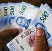 Se observa una mano que tiene varios billetes azules de 500 pesos.