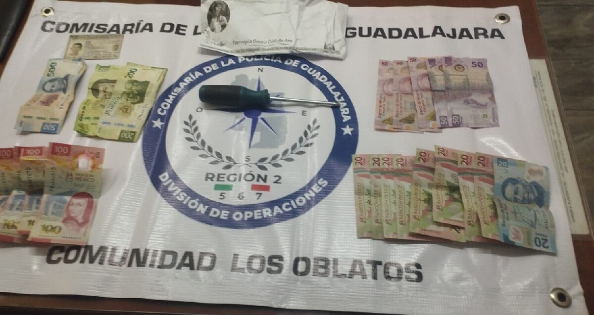 Billetes de distintas denominaciones, un desarmador y una hoja informativa de la parroquia sobre una lona de la Comisaría Municipal de Guadalajara