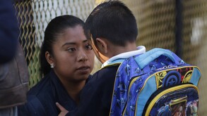 una mujer despide a su hijo en la escuela