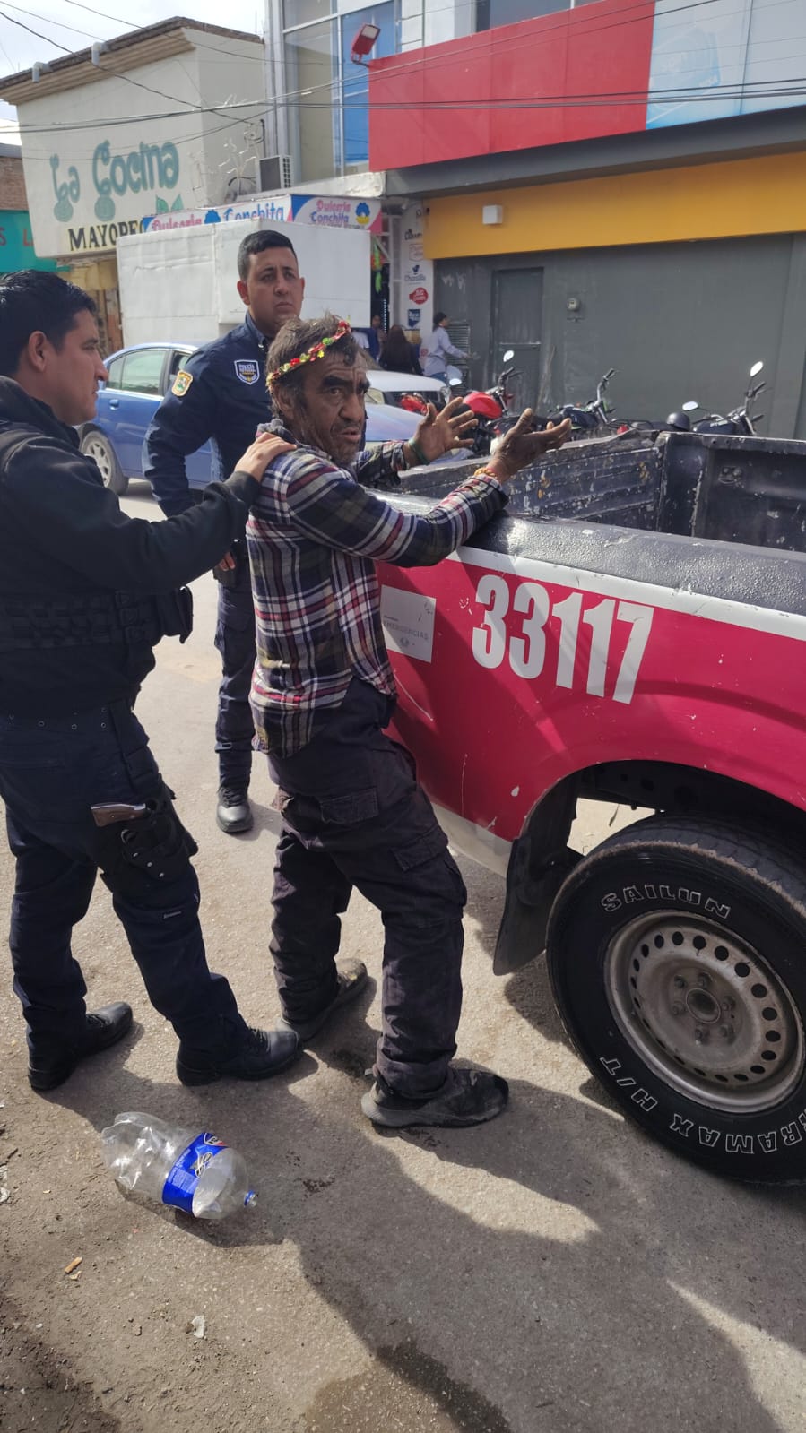 hombre en San Pedro, Coahuila siendo inspeccionado por elementos de seguridad tras ser arrestado por amenazas con arma blanca.