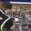Elemento de la Policía Nacional de España frente a varios paquetes de droga que fueron incautadas durante el operativo internacional