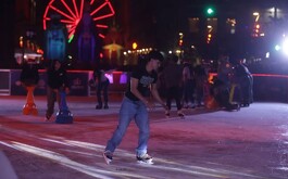 Pista de hielo y joven patinendo sobre ella