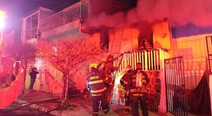 Bomberos de Guadalajara subiendo una escalera y entrando dentro de una casa a través de un balcón para apagar un incendio