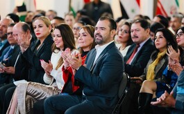 Qirino sentado junto a otras personalidades de la política