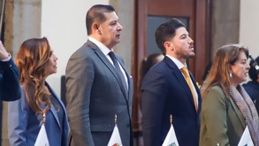 Cuatro personas paradas de perfil, mirando hacia el frente.