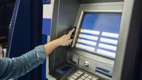 Cajero automático siendo operado por a mano de una persona