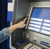 Cajero automático siendo operado por a mano de una persona