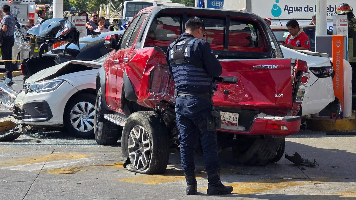 Un policía resguardando una zona donde hay varios vehículos accidentados en Puebla.