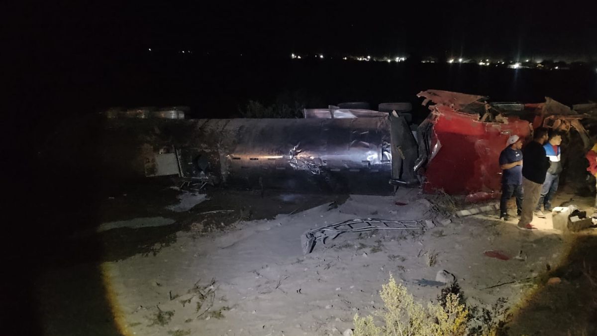 Camión cargado con leche volcado sobre los laterales de una autopista. En la imagen aparece un grupo de hombres que se encuentran revisando la zona.