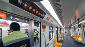 El interior de un tren de la Línea 4 (L4) del Tren Ligero de Guadalajara. Se ven asientos anaranjados y un mapa de ruta