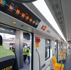 El interior de un tren de la Línea 4 (L4) del Tren Ligero de Guadalajara. Se ven asientos anaranjados y un mapa de ruta
