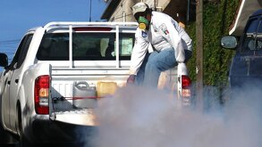 Una persona en la batea de una camioneta, portando un cubrebocas especial.