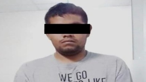 Un hombre detenido con una cinta negra cubriendo sus ojos para respetar su presunción de inocencia.