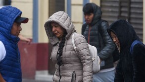 Se observa a una señora y dos hombres con chamarras y con la vista hacia abajo.