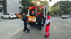 Paramédicos de la Cruz Roja dentro de una ambulancia brindado atención a hombre herido con oficiales de la Policía de Guadalajara presentes