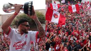 Alexis Vega levantando la copa de campeón en el autobús del Toluca en el desfile acompañados de miles de aficionados rojos.