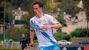 Un hombre delgado jugando un partido de futbol vistiendo una playera del Club Puebla.