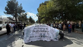 Se observa a una multitud donde hay hombres y mujeres y un carro con una lona blanca.