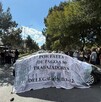 Se observa a una multitud donde hay hombres y mujeres y un carro con una lona blanca.