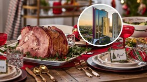 Mesa navideña con un jamón glaseado y decoración festiva. Incluye una foto circular superpuesta de un hotel moderno y alto durante el atardecer.