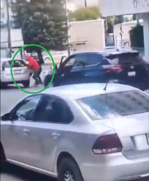 Personas abordando un vehículo a prisa en calles de Puebla.