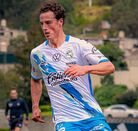 Un hombre delgado jugando un partido de futbol vistiendo una playera del Club Puebla.
