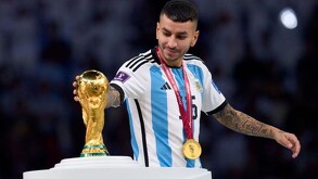 Ángel Correa tocando la Copa Mundial de la FIFA ganada en Qatar 2022.